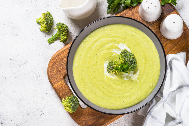 Broccoli cream soup in the bowl on white table. - Fotó, kép