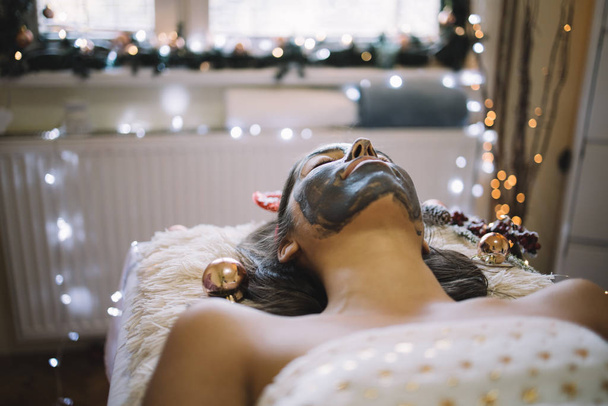 Girl with facial mask lying in beauty salon - Фото, зображення