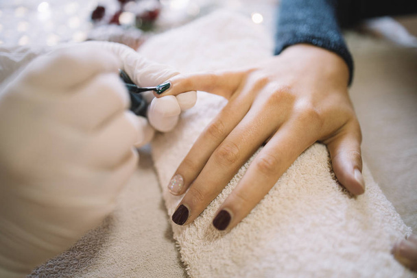 Hands of a manicurist working on nails of a girl - Фото, изображение