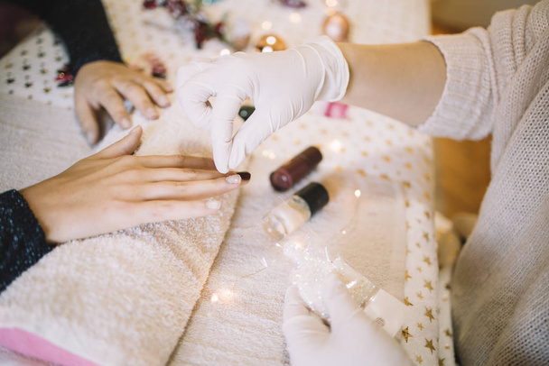 Beautician pouring white brocade over womans nails - Foto, immagini
