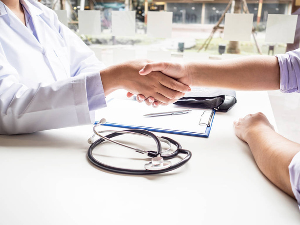 Artsen en patiënten schudden elkaar de hand na het weten van de resultaten van het gezondheidsonderzoek - Foto, afbeelding