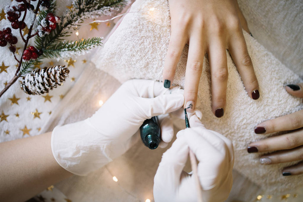 Manicurist applying nail polish on womans ring finger - 写真・画像