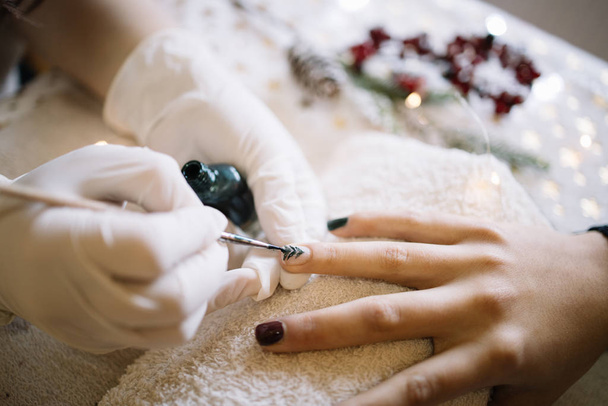Woman having Christmas nail manicure at beauty salon - Foto, immagini