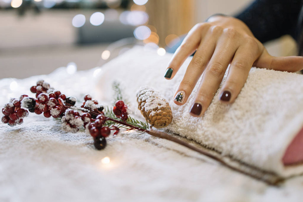 Woman showing her Christmas manicure at nail salon - Фото, изображение