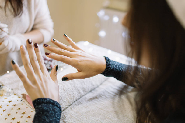 Girl looking her nails after manicure session - Photo, image