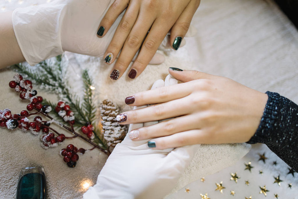 Girl showing her Christmas manicure at nail salon - Foto, Imagen