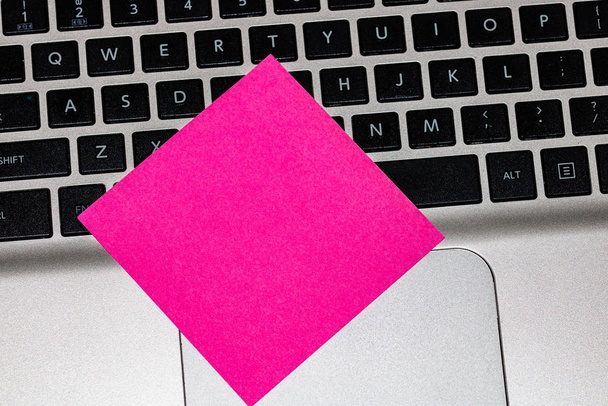Blank pink sticky note, post it on keyboard. Close up. - Zdjęcie, obraz