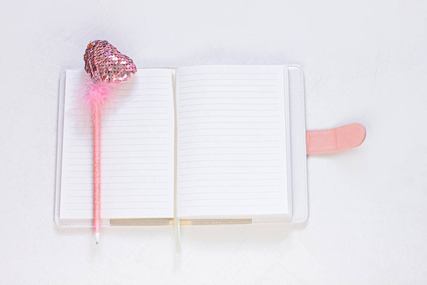 Valentine flatlay. Prázdný deník, růžová pera ve tvaru srdce na bílém pozadí. Notebook mockup, roztomilý dívčí styl. - Fotografie, Obrázek