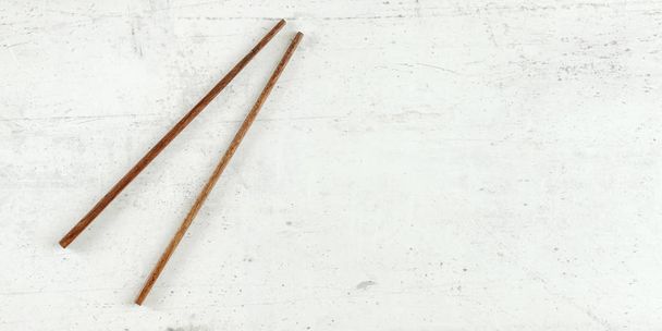 Top down view - pair of dark wood chopsticks on white board. Can - Photo, image