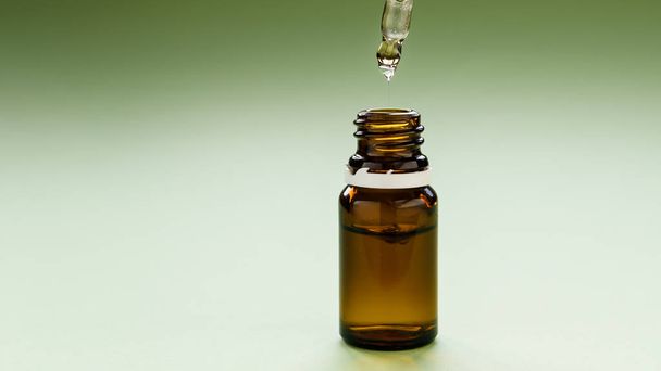 cosmetologia, cuidados com a pele, uma linha de garrafas de vidro com pipetas e ácido hialurônico dentro em um fundo verde
 - Foto, Imagem