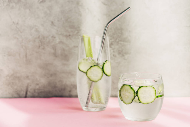fresh lemonade with ice, celery, straw and cucumber slices in sunlight - Photo, Image