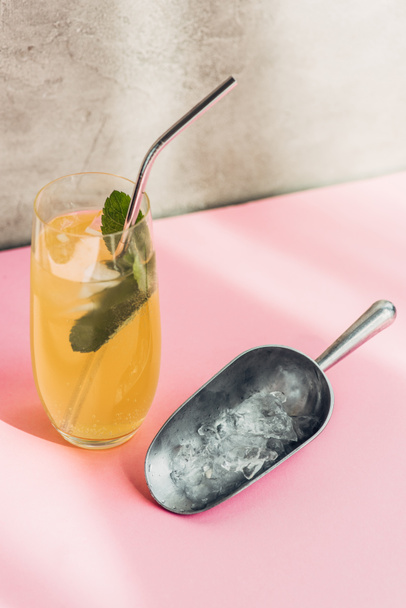 fresh lemonade with ice, mint, straw near ice scoop in sunlight - Photo, image