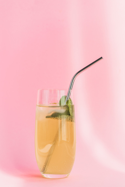 fresh lemonade with ice, straw and mint in sunlight on pink background - Photo, Image