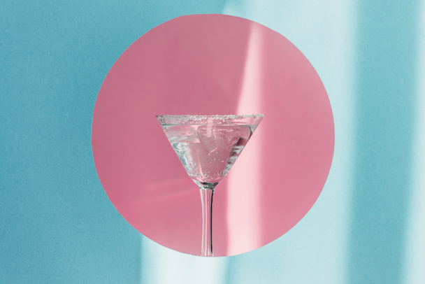gin tonique en verre de martini en cercle rose sur fond bleu au soleil
 - Photo, image