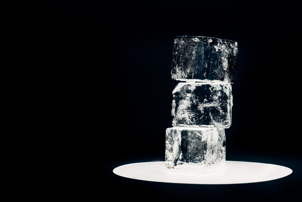 cubitos de hielo cuadrados en círculo iluminado aislado en negro
 - Foto, imagen