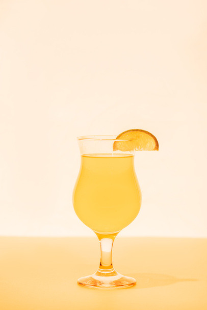 gelber Cocktail mit Zitrusscheibe auf hellem Hintergrund - Foto, Bild