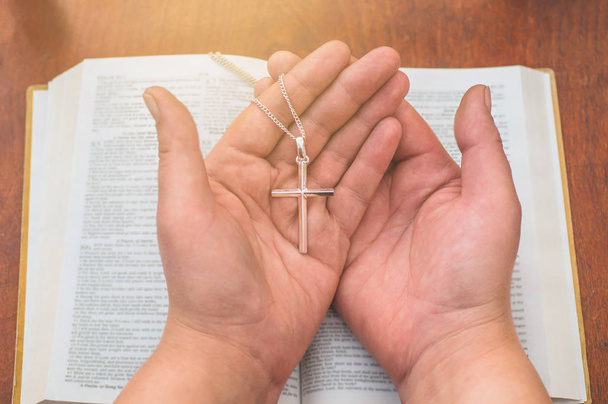 Femme tenant la croix à la main sur le fond de la bible
 - Photo, image