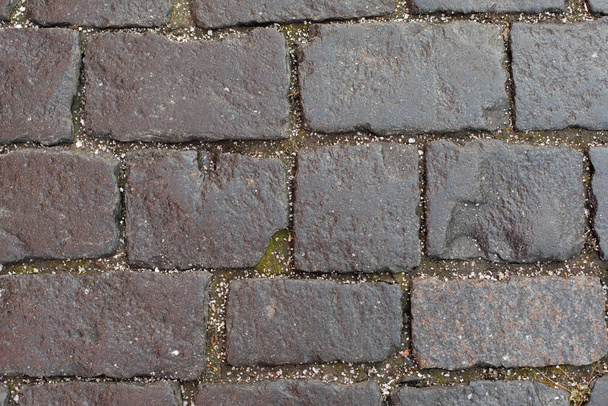 Текстура каменного тротуара с мелкими крошками ледяного града. Старые прочные булыжники дороги, каменный тротуар. Структура фона серого цвета
 - Фото, изображение
