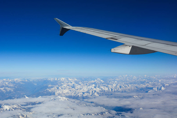 View from airplane to mountains and clouds - 写真・画像