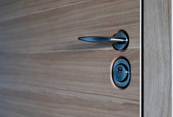 door lock and handle close up, beautiful modern wooden entrance door to the apartment - Photo, Image