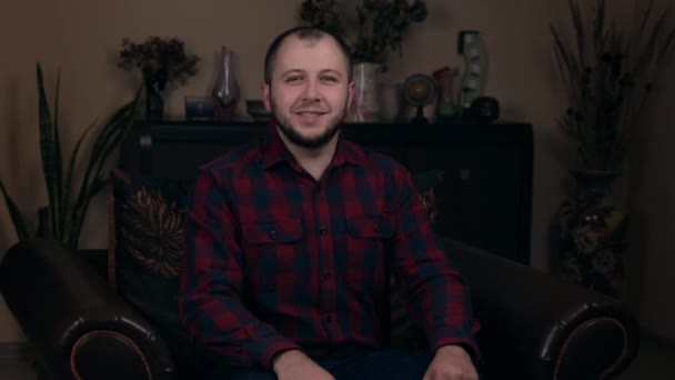 The influential Bearded Young guy, a blogger, of European appearance, sits in a chair in a plaid shirt and asks everyone to like the video. Social Media Blogging Concept. - Footage, Video