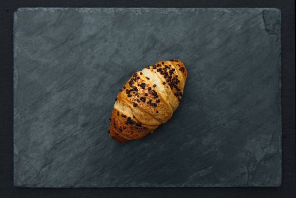 frisches und schmackhaftes Croissant mit Schokolade auf Holzgrund - Foto, Bild