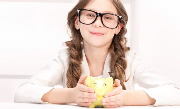 Little girl with piggy bank - Фото, изображение