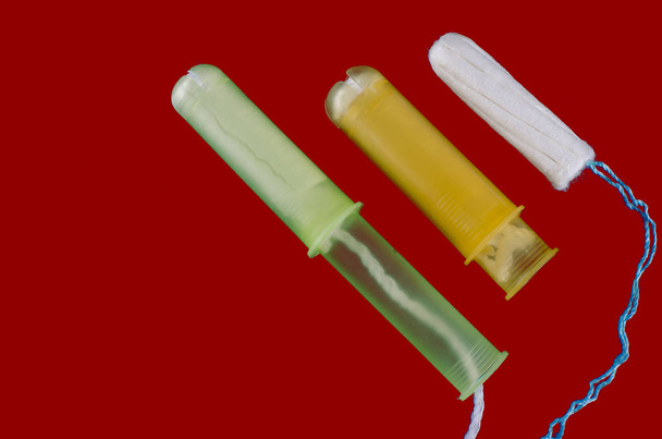Menstruatieconcept. Bescherming van vrouwelijke hygiëne. Katoen tampons op rode achtergrond - Foto, afbeelding