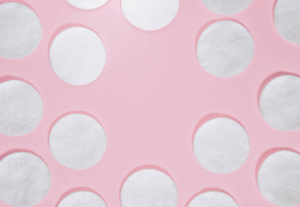 Προϊόντα υγιεινής: στρογγυλά λευκά βαμβακερά μαξιλάρια και το βαμβάκι επιχρίσματα είναι σε έγχρωμο φόντο - Φωτογραφία, εικόνα
