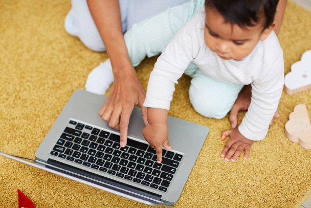 Primo piano di bambino che digita sulla tastiera del computer sul computer portatile con la madre seduta vicino e l'insegnamento
 - Foto, immagini