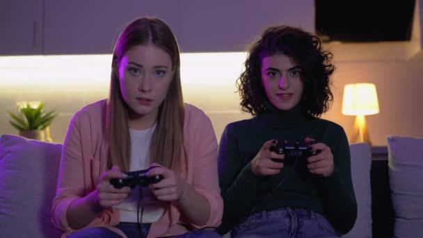 Pretty girls playing video game with joysticks at home, competitive spirit - Filmagem, Vídeo