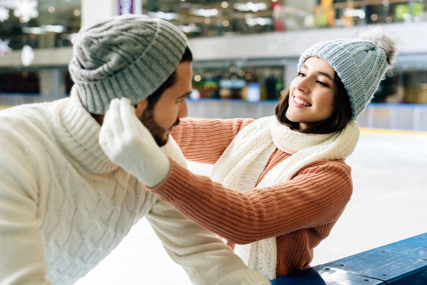 young smiling couple wearing hats on skating rink - Photo, Image