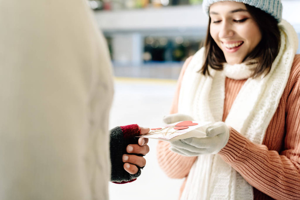 man giving greeting card on valentines day to woman on skating rink - Photo, Image