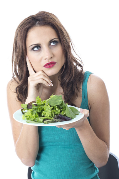 Atractiva mujer joven comiendo ensalada de hojas verdes
 - Foto, imagen