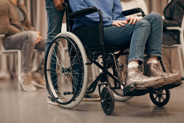 Detailní záběr mladé zdravotně postižené ženy sedící na invalidním vozíku s ostatními lidmi v pozadí při návštěvě terapeutické lekce - Fotografie, Obrázek