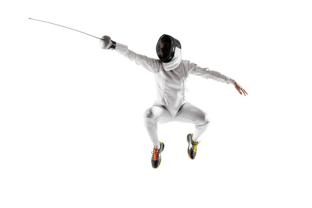 Teen girl in fencing costume with sword in hand isolated on white background - 写真・画像