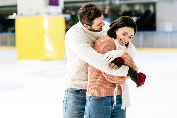 sonriente pareja abrazos y divertirse en pista de patinaje
   - Foto, Imagen