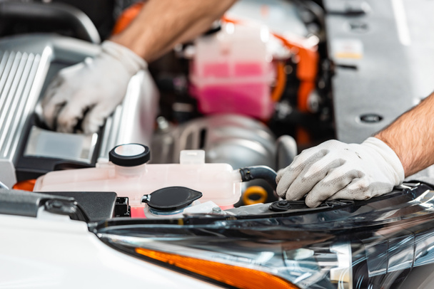 cropped view of mechanic inspecting car engine compartment  - Photo, Image
