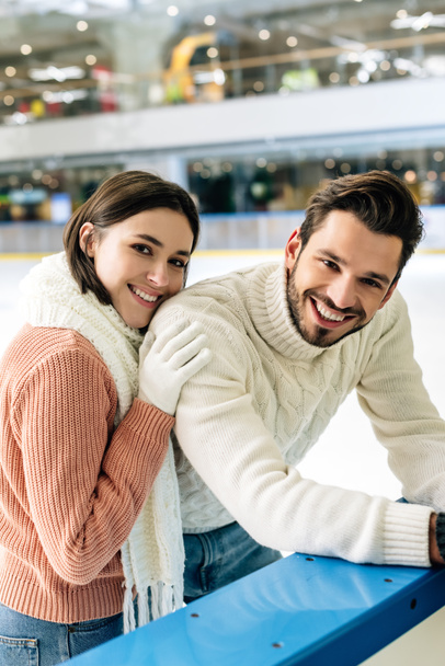 pareja joven en suéteres pasar tiempo en pista de patinaje
   - Foto, Imagen