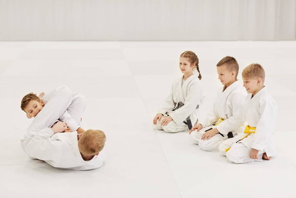 Trener walczy i pokazuje technikę karate dzieciom na siłowni - Zdjęcie, obraz