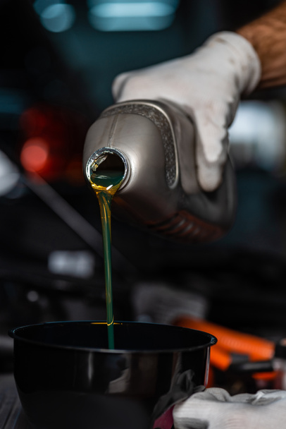 vista recortada del aceite lubricante de vertido mecánico en el embudo
  - Foto, imagen