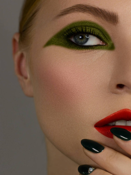 Half Beautiful close up sexy young woman evening make up dark eye eyelashes dyed and green liner, makeup artist cosmetic beauty salon spa. Long green nails, clean skin and red nude lipstick. - Valokuva, kuva