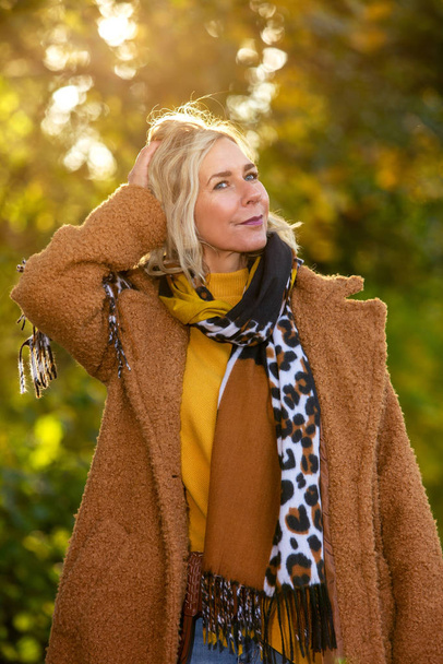 blond woman in her 40s walking in park and enjoying the autumn s - Foto, immagini