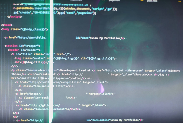 Detailní záběr počítačové obrazovky s kódy a symboly s počítačovým hackerem v černém oblečení  - Fotografie, Obrázek
