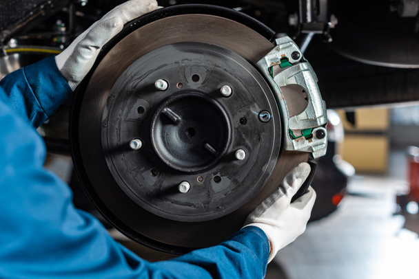 cropped view of mechanic adjusting assembled disc brakes with brake caliper - Foto, Imagem
