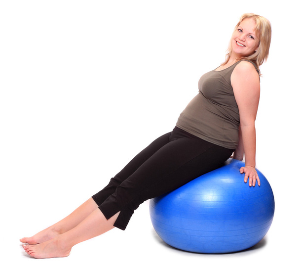 Толстая молодая женщина, сидящая на синем мяче
 - Фото, изображение