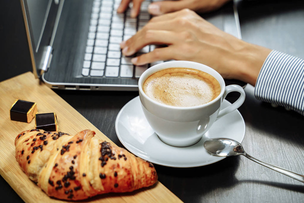 Croissant with chocolate and coffee on the desktop. Business breakfast concept. - Foto, Bild