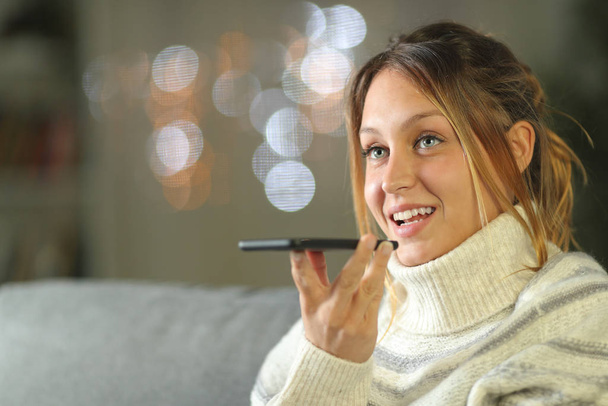 Happy woman using voice recognition on phone in winter - Φωτογραφία, εικόνα