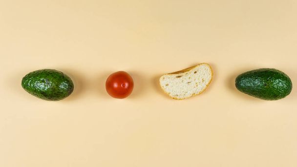 Flat lay of ripe avocado on yellow background, tomato and bread. - Fotoğraf, Görsel