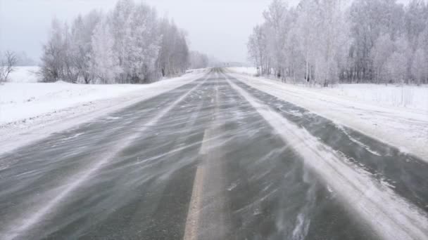 El viento sopla de la nieve a lo largo de la carretera
. - Metraje, vídeo